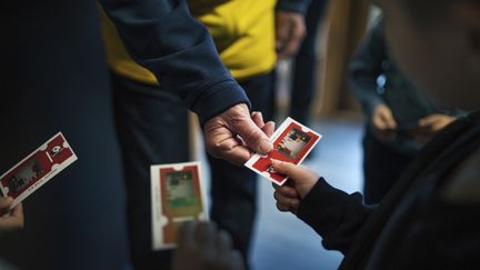 En hand sträcker ut en biobiljett. En barnhand tar emot biljetten.