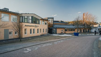En skolbyggnad med texten Skutehagsskolan Göteborgs stad på fasaden med väg framför sig.