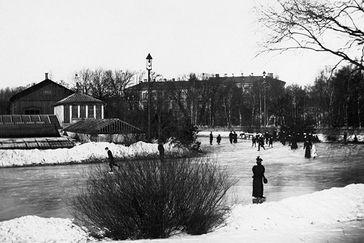 Black and white image of people skating on the water beside The Garden Society of Gothenburg.