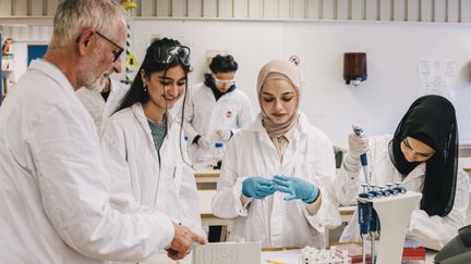 En lärare undervisar elever i en kemisal.