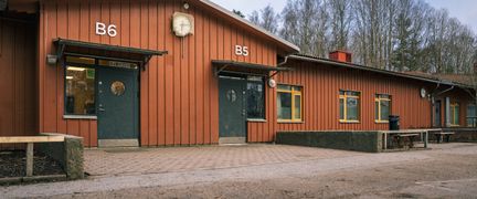 Skolbyggnad i rött trä med två entréer