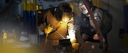 Elev som svetsar medan lärare kontrollerar att momentet utförs korrekt. Foto: Tim Kristensson