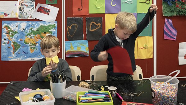 Två barn pysslar med papper