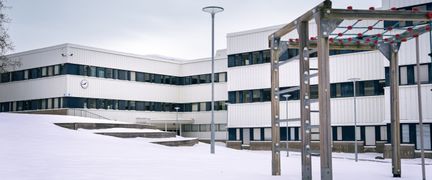 En klätterställning framför en snötäckt kulle utanför Gårdstensskolan.