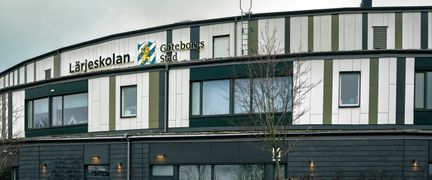 En vit skolbyggnad med en skylt med texten Lärjeskolan på fasaden.