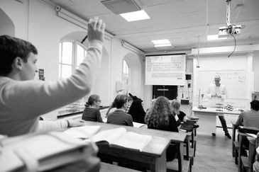 Elev som räcker upp handen på lektion