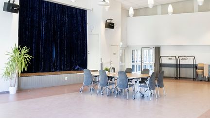 En mindre scen och ett konferensbord med stolar. 