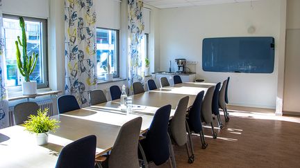 Ett långt konferensbord med många stolar. 