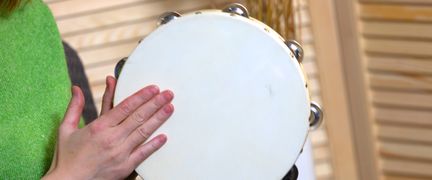 En person spelar tamburin.