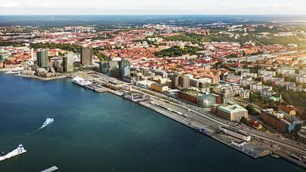 Flygbild över Masthuggskajen en solig sommardag. En färja närmar sig kajen från vattnet.