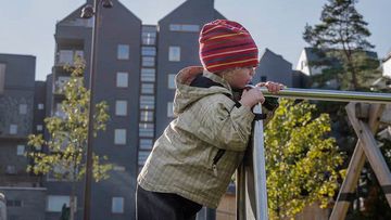 ett barn framför höga hus