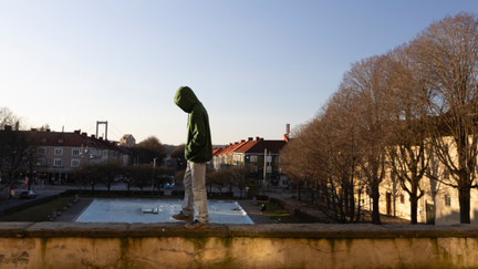 Pojke med luvtröja går på en mur vid Plaskis i Majorna.