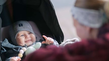 Barn som ligger i en barnvagn.