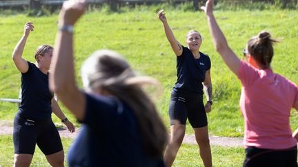 Männiksor som gympar ute på en gräsplan