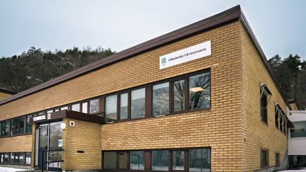 En skolbyggnad i tegel med en skylten Utbyskolan 1-9 resursskola på fasaden.