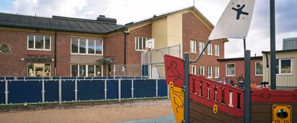  En skolgård med ett piratskepp framför skolbyggnaden.