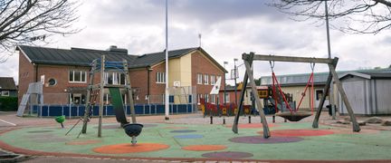 En lekplats med gunga, rutschkana och lekskepp