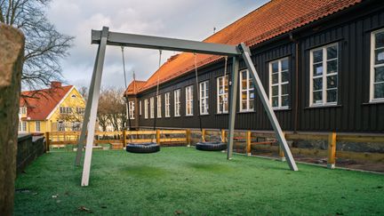 Några gungor utanför Bagaregårdsskolan. Skolans huvudbyggnad syns i bakgrunden.