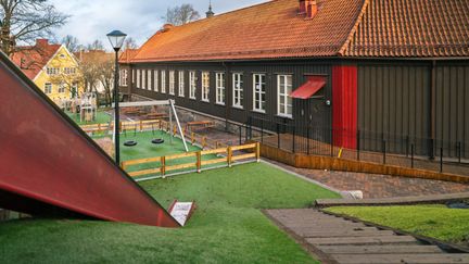 En rutschkana utanför Bagaregårdsskolan. Några gungor och skolbyggnaden kan ses i bakgrunden.