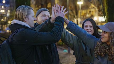 Fyra ungdomar gör high five. 