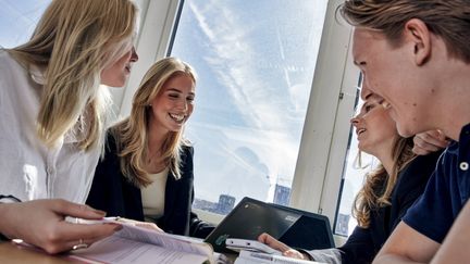 Elever som studerar tillsammans i ett klassrum.