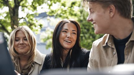 Tre elever som samtalar utanför skolan.