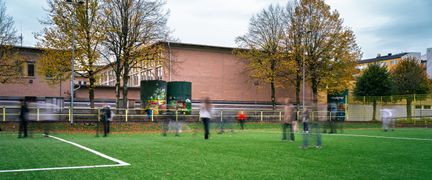 En fotbollsplan med ett par barn som spelar fotboll utanför Lövgärdesskolan.