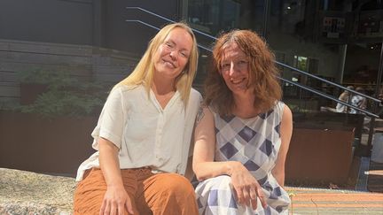 Biblioterapi-handledarna sitter bredvid varandra utomhus.