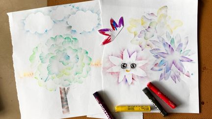 En teckning med träd och blommor. 4 kritor ligger på teckningen.to: Jenny Forsgren