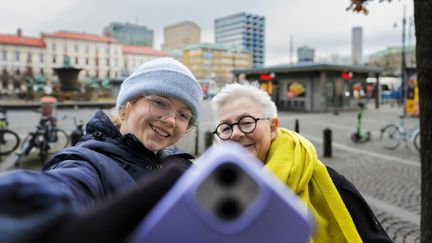 Ett barn och en äldre person tar en selfie tillsammans.