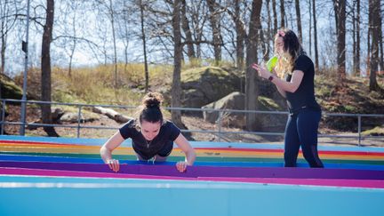 Två personer tränar utomhus tillsammans.