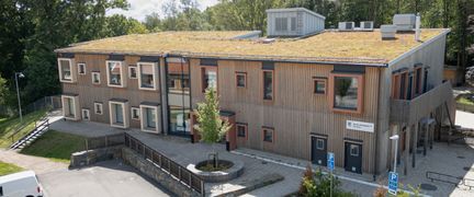 en träbyggnad i två våningar med sedumtak.