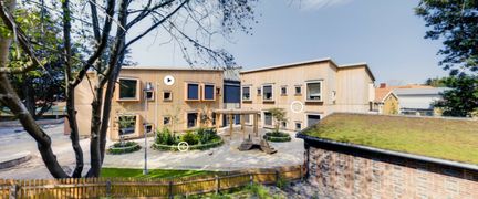 en träbyggnad i två våningar. På bilden syns pilar som indikerar att man får mer information om man klickar på dem.