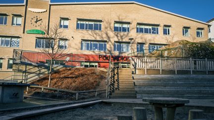 En skolbyggnad med trappor som leder upp till den.