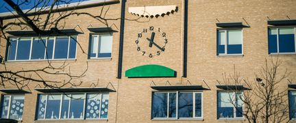 En byggnad i tegel med en klocka på fasaden.