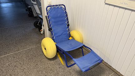 En blå sits och ryggstöd med stora breda gula hjul.