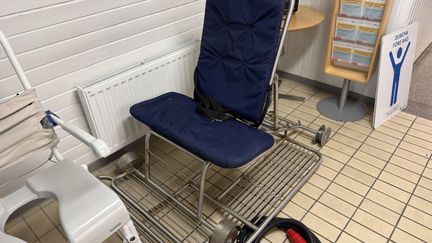 En blå sits och ryggstöd på en ställning i metall.