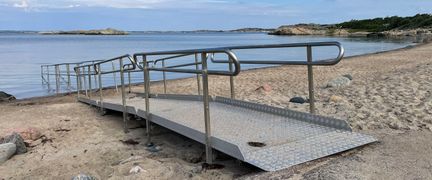 En ramp på en sandstrand som leder ner i havet.