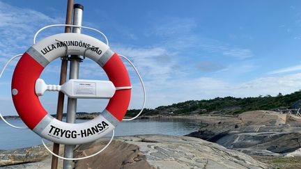 Livboj med texten Lilla Amundöns bad, i bakgrunden klippor och hav.