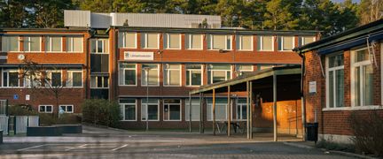 En skolgård framför en skolbyggnad i tegel.