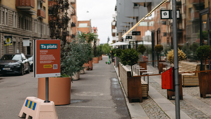 En uteservering på Teatergatan. På rad längst med gatan står växter som ger mer plats åt fotgängare.