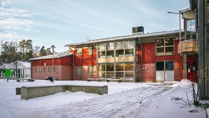 Nytorpsskolans skolgård med några bänkar och träd i bakgrunden.