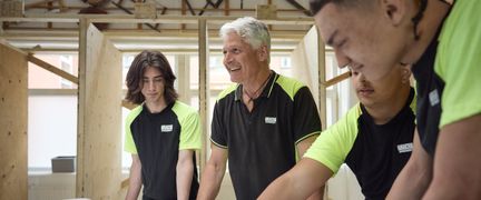 En lärare med elever i en träverkstad.