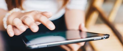 En person håller en surfplatta i händerna.