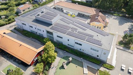 Ett flygfoto med en överblick av Påvelundsskolans byggnader. På huvudbyggnadens tak kan man se solceller.