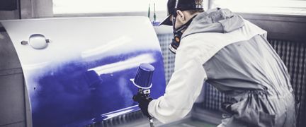 En elev lackerar en bildörr.