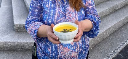 En kvinna som håller i en skål med soppa