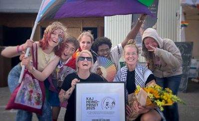 Ungdomar håller i ett diplom och en Pride-flagga. 