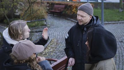 Ungdomar som pratar med en vuxen utomhus