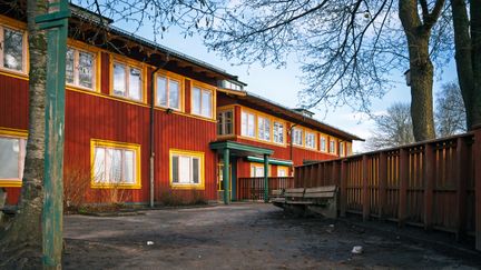 Överblick av Nya varvetskolans entré med en bänk och ett staket i bakgrunden.